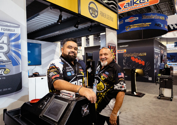 Tommy Garcia and Mikey B. standing in front of BG Prod. booth at AAPEX