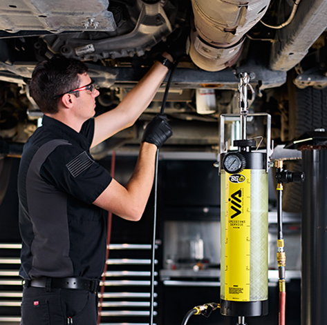 Technician under a car using the Emissions Service VIA®