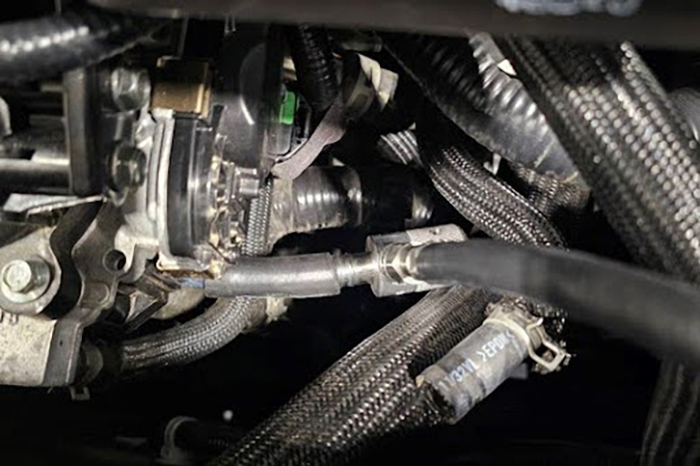 Close up image of AE03 adaptor installed on Nissan 1.5L engine.